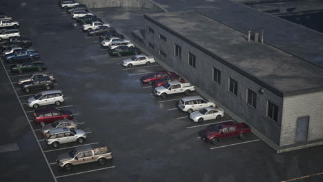 a large parking lot filled with cars and a grey building