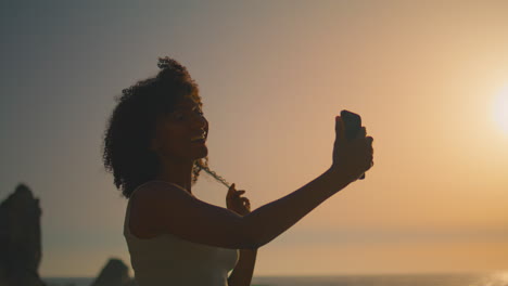 woman taking self photo on smartphone at sunrise closeup. girl posing for selfie