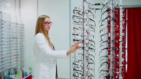 woman at glasses shop. smiling young woman choosing glasses in shop