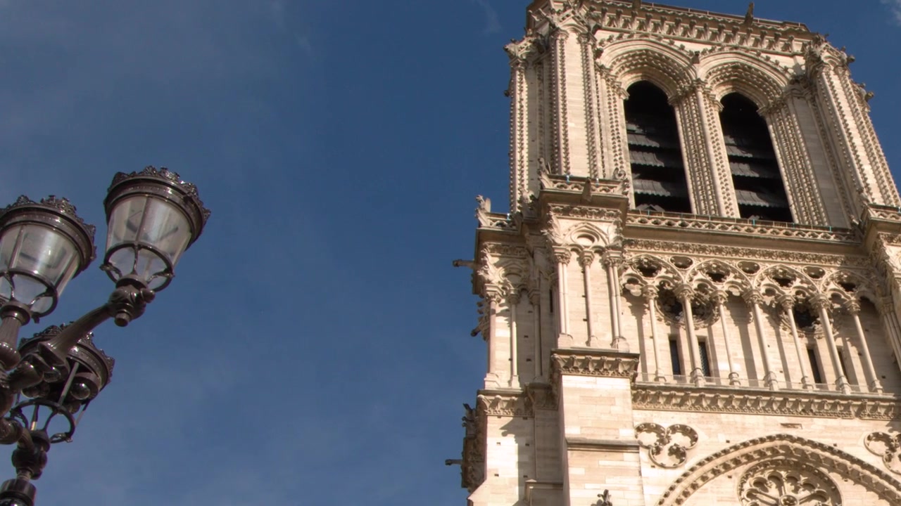 Paris, Fransa'da mavi gökyüzüne karşı Notre Dame Katedrali kulelerinin alçak açı çekimi.