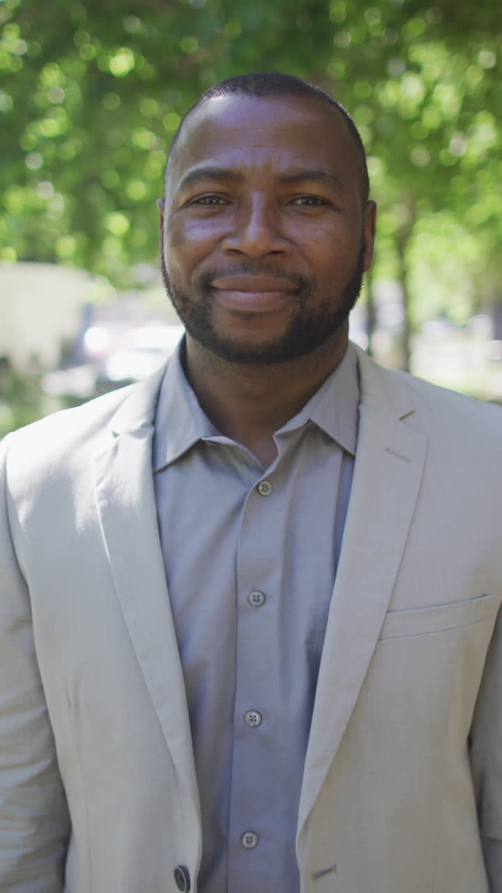 retrato de video vertical de un hombre afroamericano sonriendo en una calle de la ciudad soleada