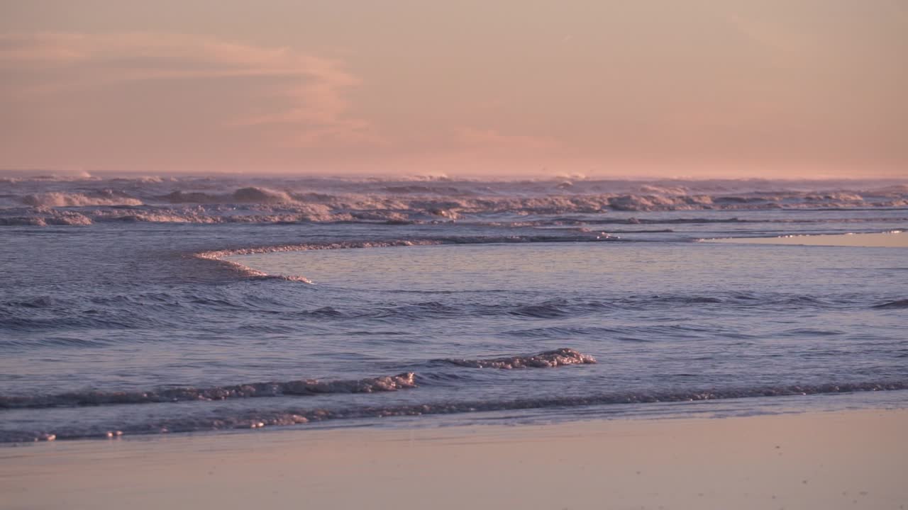 paisaje de ondas que salpican la costa durante la puesta de sol en cámara lenta - tiro estático