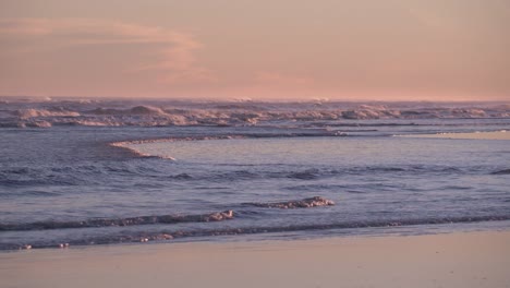 scenery of rolling waves splashing through coastline during sunset slow motion - static shot