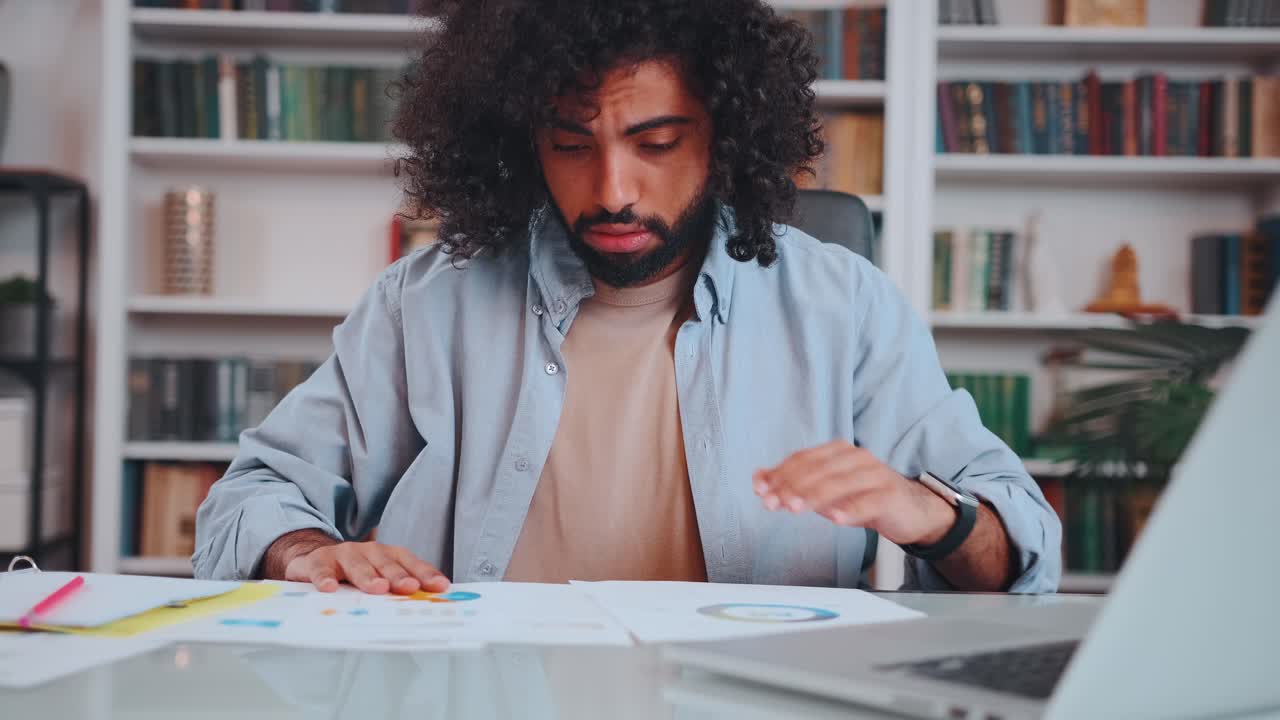 Middle eastern man financier nervous looking through analytical reports