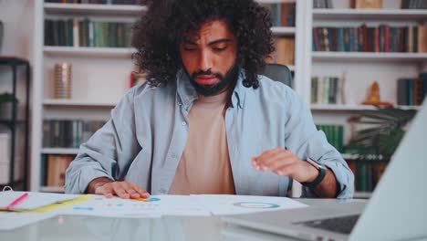 middle eastern man financier nervous looking through analytical reports