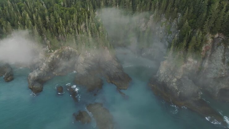 Breathtaking Aerial View Looks Down on Misty Cliffs and Blue Waves on Maine Coast