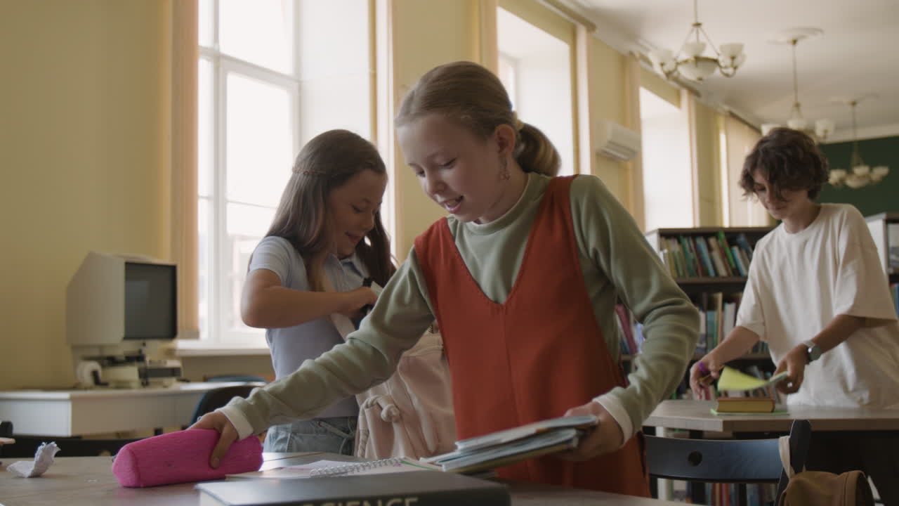 Children preparing and packing their school supplies in a library