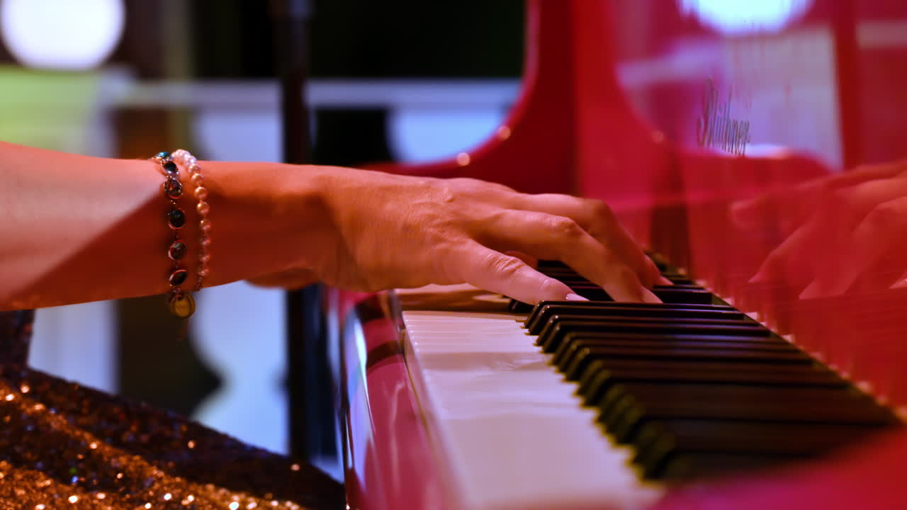 Close-up of an elderly woman playing a red piano