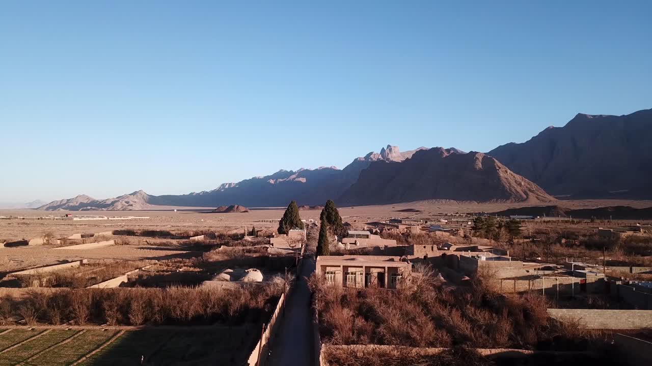viejos cipreses gemelos sagrados en un antiguo pueblo de zoroastrianos mobarakeh en yazd irán en medio del desierto con el paisaje de la carretera de tránsito tir y las montañas en el fondo al atardecer