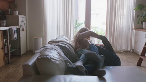 cheerful-young-couple-playfully-falling-onto-sofa-having-fun-romantic-relationship-embracing-enjoying-happy-lifestyle-together-at-home