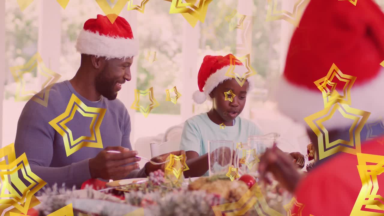 animación de estrellas sobre padre e hijo afroamericanos con sombreros de santa comiendo la comida de navidad