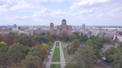 Slow-revealing-descending-aerial-shot-of-Tasmajdan-Park-and-St-Marko-church,-Belgrade