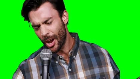 male musician singing while playing guitar