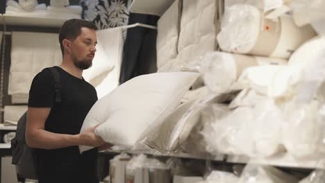 man shopping for pillows in a home goods store