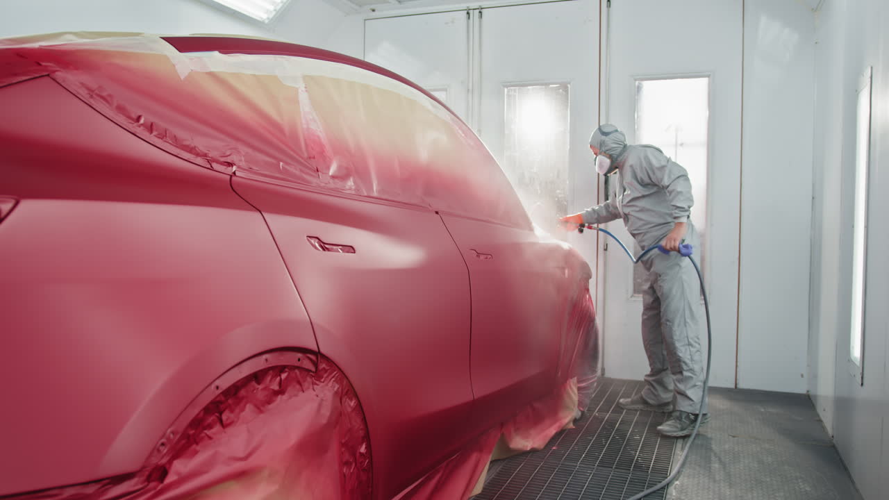 Red Electric Car Spray Painting in a Paint Booth