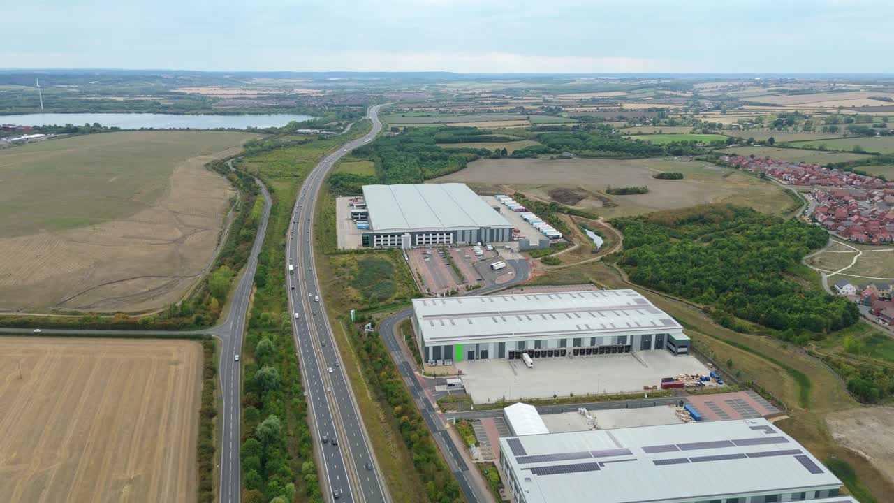 Wide aerial panorama of Bedford England industrial area with busy distribution centres, factories, warehouses and motorway transport infrastructure