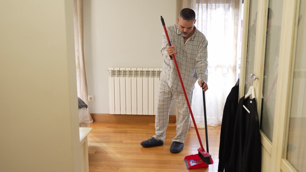 Mann som feier gulvet på soverommet