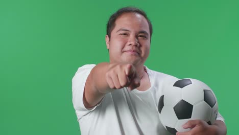 man pointing at soccer ball on green screen
