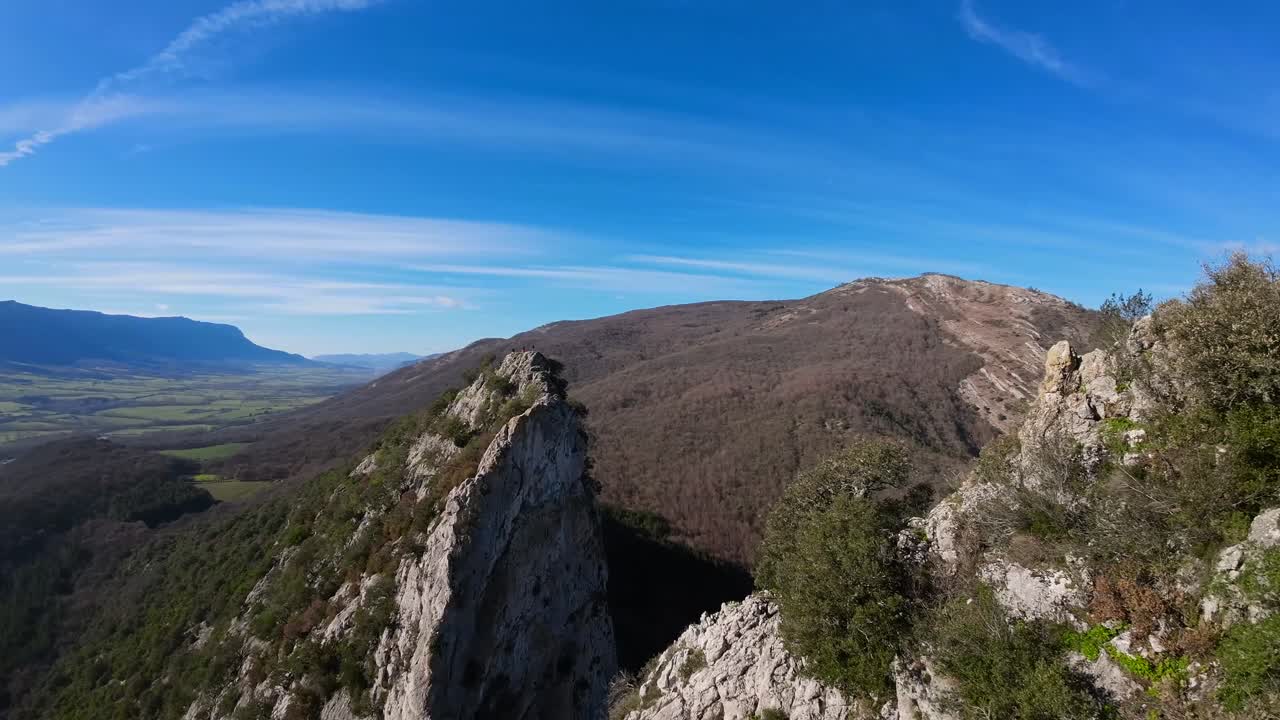우뚝 솟은 돌산 꼭대기에서 찍은 fpv 드론 항공 이미지, 녹색, 회색, 푸른 하늘의 음영이 있는 차분한 자연 이미지