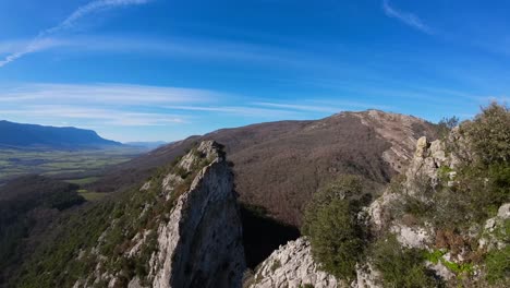 imagen aérea de drones fpv tomada desde la cima de una imponente montaña de piedra, una imagen natural relajante con tonos de cielo verde, gris y azul