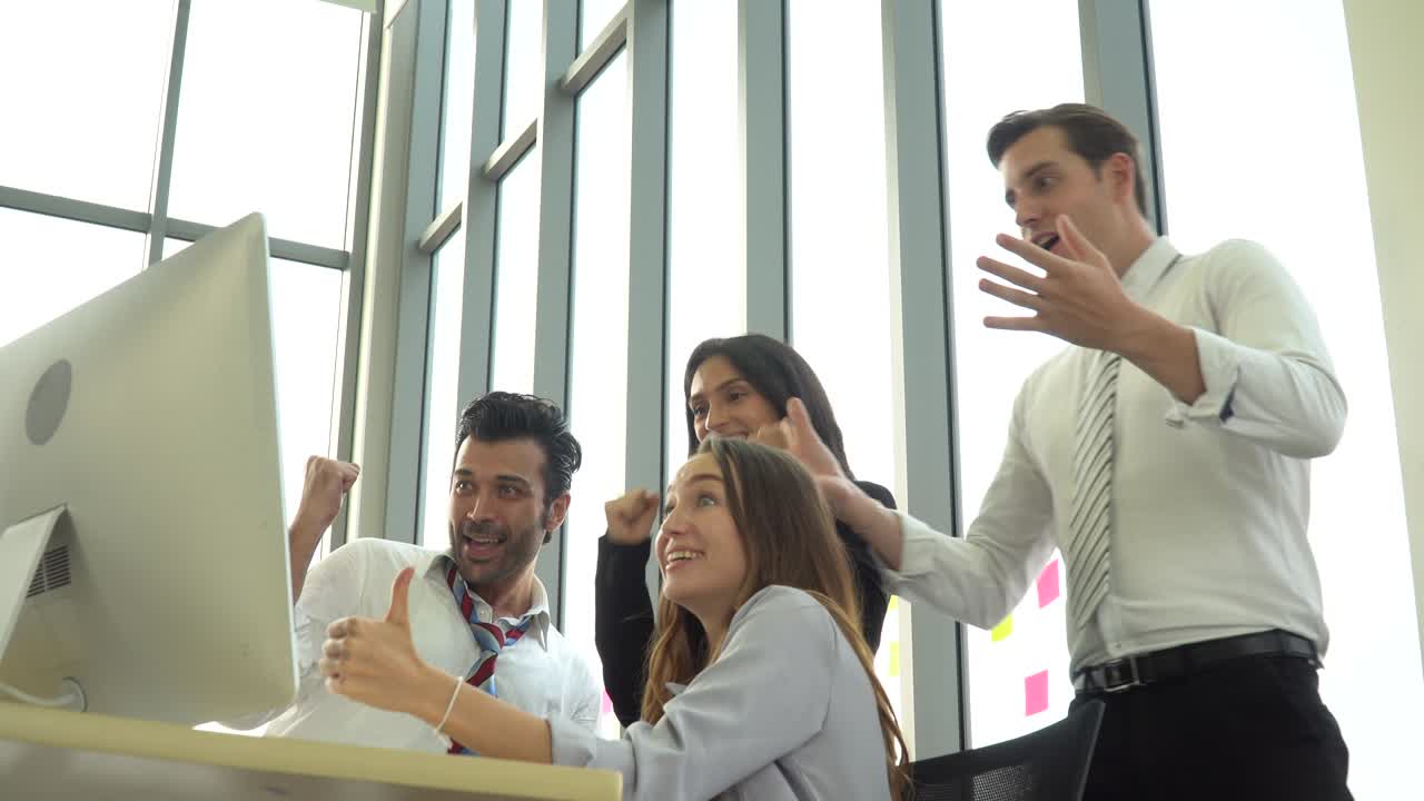 grupo de personas de negocios que se reúnen con la computadora emocionada levantan la mano para celebrar el éxito juntos en la oficina. conferencia de equipo de marketing tormenta de ideas. trabajador de pie y hablando con su colega.