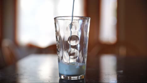leche vertida en el vaso en cámara lenta