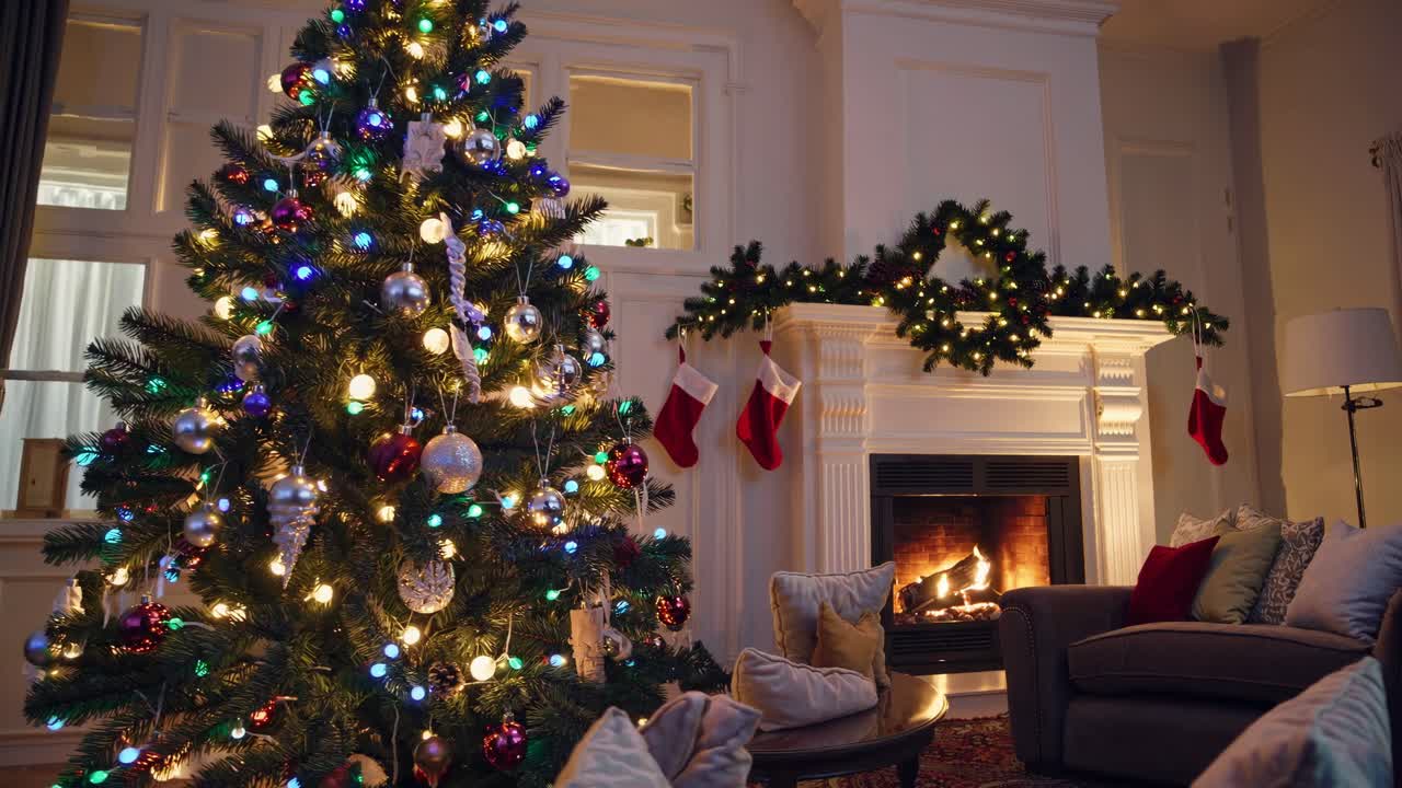 Cozy living room video with a low-angle view of a decorated Christmas tree and a lit fireplace