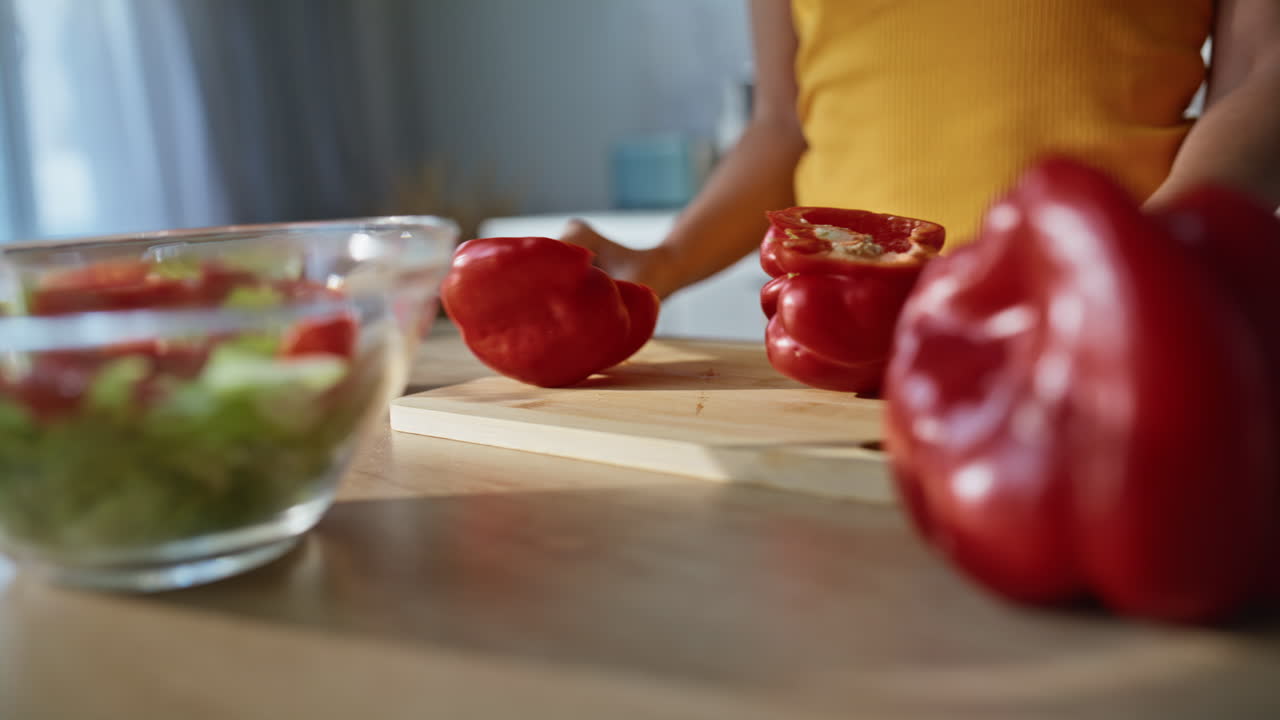 Cook hands slicing pepper on chopping board home kitchen closeup. Woman cutting