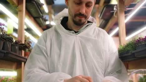 man in protective suit in a greenhouse