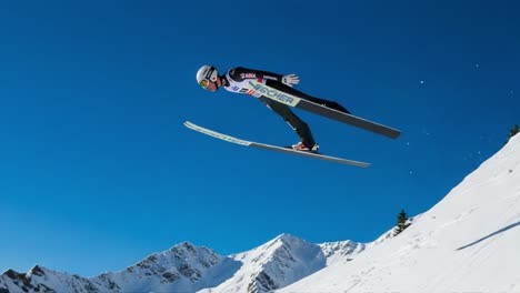 dynamic ski jumping in stunning winter landscape: thrilling athlete soars through the air against backdrop of majestic snow-capped mountains and clear blue sky