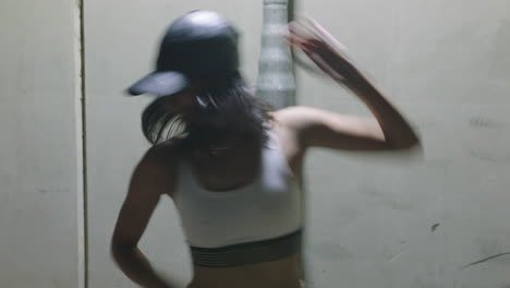 dancing-woman-young-street-dancer-woman-practicing-modern-freestyle-dance-moves-in-city-at-night-wearing-hat