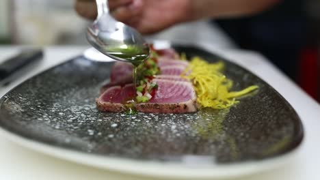 a chief puts oil on a plate, close up shot, insert shot