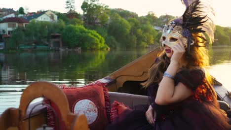 beautiful woman in black dress with carnival mask riding on gondola, venice, italy.