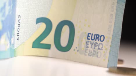 close up of 20 euro bill and coins, movement from right to left