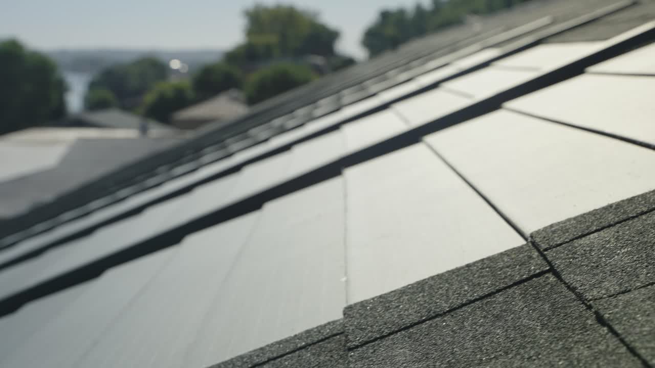 imágenes de drones de primer plano que destacan las tejas solares en un techo comercial bajo un cielo despejado.