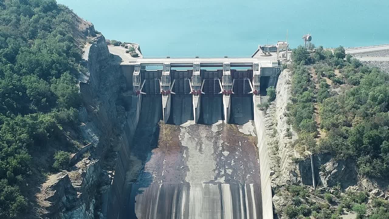 Water stroomt door de dam bij het Colbun-meer in Chili op een zonnige dag.