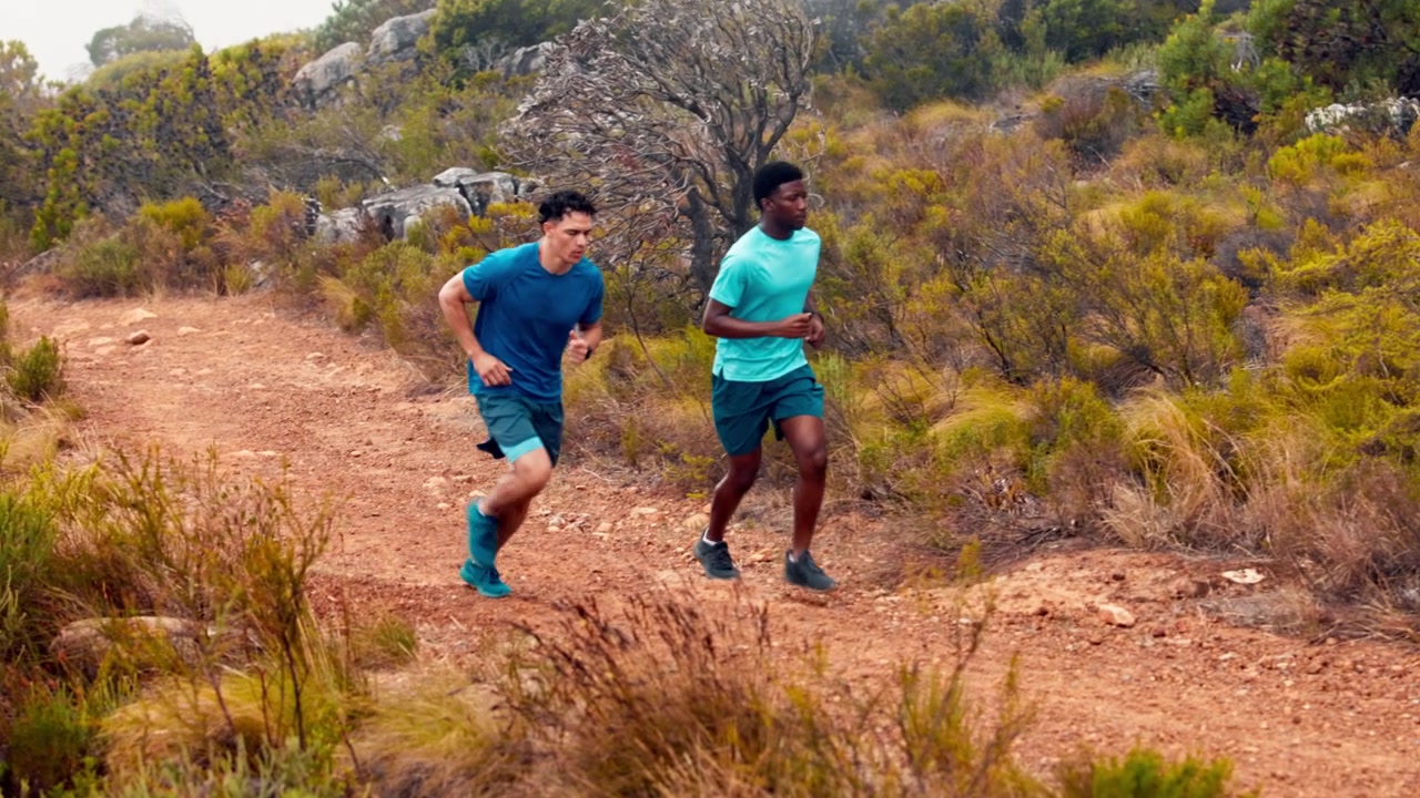 Two Men Running Together on a Dirt Trail in Nature