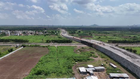 highway stretching through the green plains of amaravathi, filmed from above.