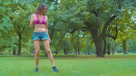 Petite-Caucasian-Girl-Showing-Zumba-Dance-Moves-on-Grass-in-Public-Park