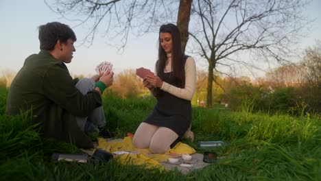 young couple playing cards in a park