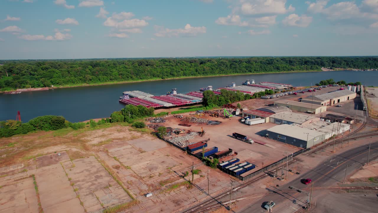 Commercial barge terminal operations along McKellar Lake showing red cargo vessels warehouses equipment industrial waterfront