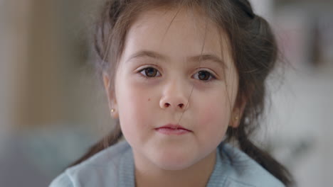 portrait-beautiful-little-girl-smiling-looking-at-camera-cute-child-with-playful-expression-running-hand-through-hair-enjoying-happy-childhood-4k