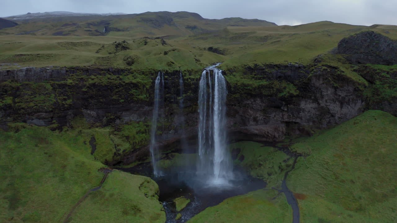 Aerial: Slow panning shot of Seljalandsfoss waterfall in Iceland during dusk
