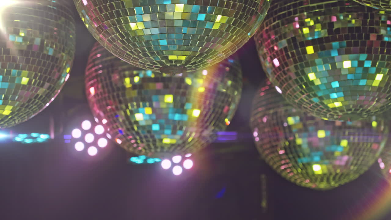 Sfere da discoteca rotanti che riflettono luci colorate da festa.