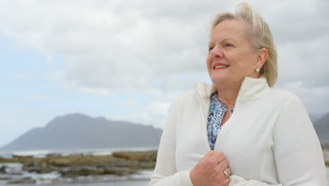 front view of old caucasian senior woman standing at beach 4k