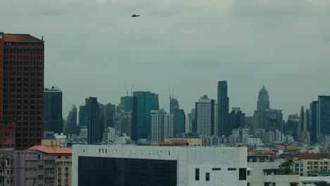 royal thai military helicopter flying over bangkok city skyline, thailand in true 4k dci