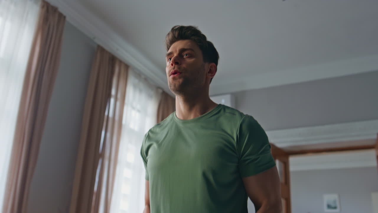 Strong bodybuilder lifting dumbbell at home workout close up. Guy training hands