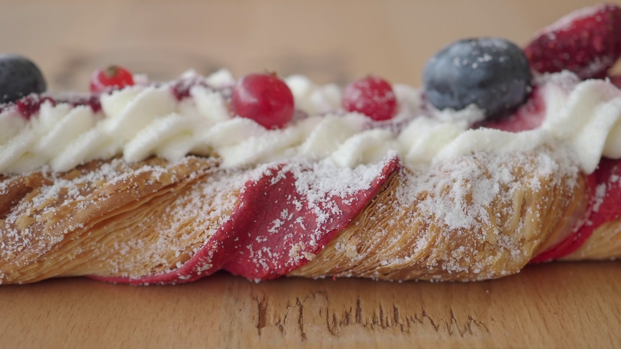 Close-up of Braided Pastry with Berries, Whipped Cream, and Powdered Sugar