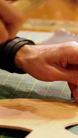 primer plano de una artesana clavando cuero