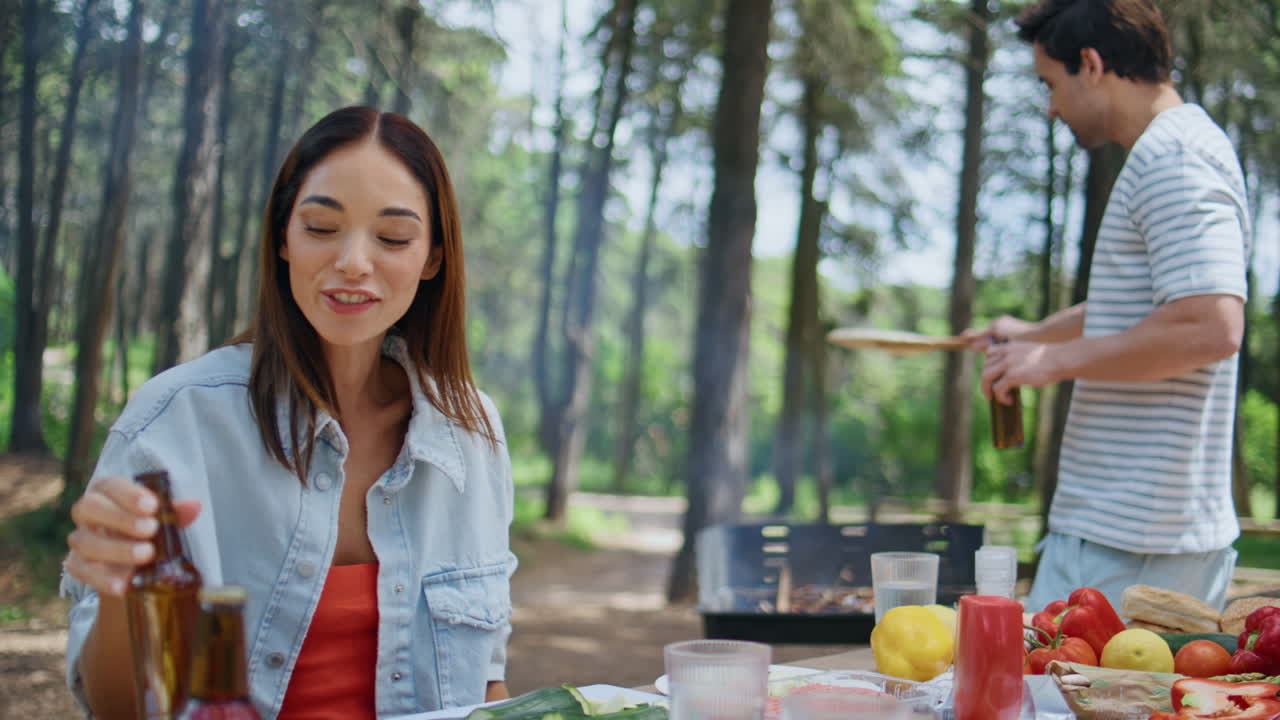 Happy friends toasting beer at forest bbq closeup. Smiling people drinks